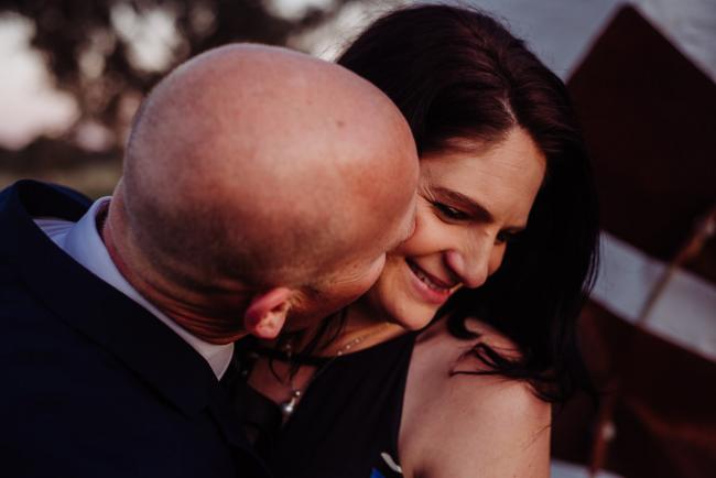 Man kissing his partner on the cheek during a family photography session at Perry's Paddock, Perth