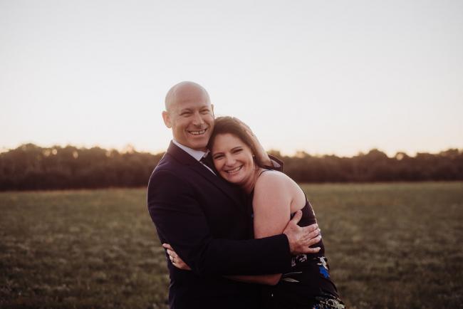 Couple embracing and smiling at the camera during a Perth family session at Perry's Paddock