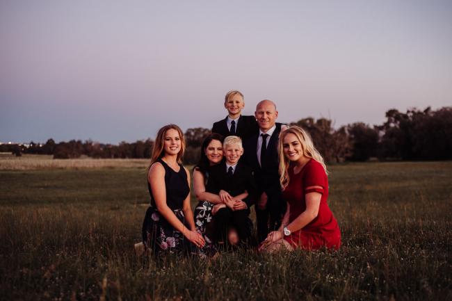 20180909-DSC_6279-3 Family of 6 sit on the grass and smile at the camera during golden hour family photography Perth session at Perry's Paddock