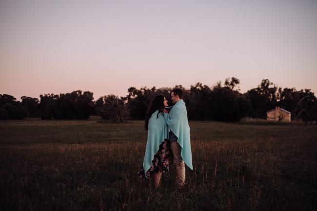 Couple standing with a blanket around each other and facing each other during a couples photography session at Perry's Paddock, Perth