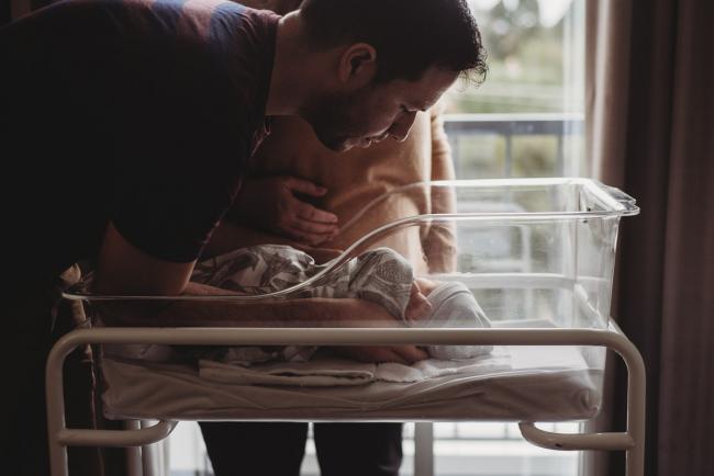 Dad lifting new baby out of hospital bassinet during Perth Fresh 48 session