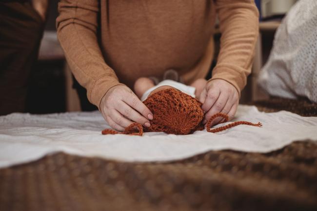 Mother placing bonnet on new baby's head during Perth Fresh 48 session