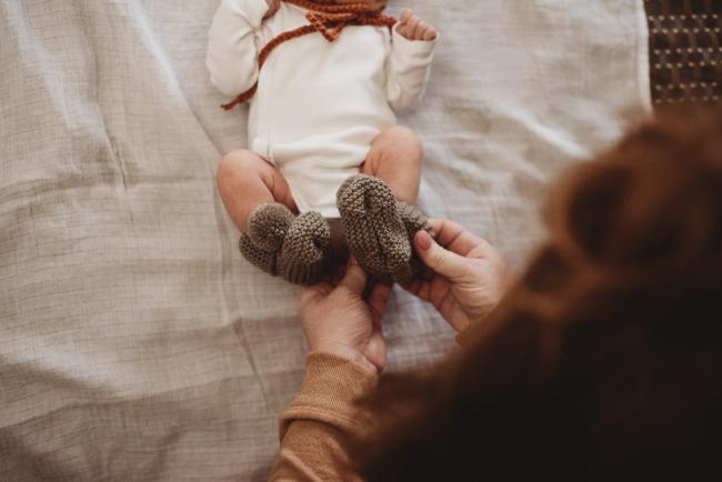 Mother placing booties on new baby's feet during Perth Fresh 48 session