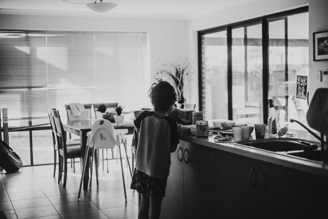 black and white image of a boy in the kitchen by family photographer perth