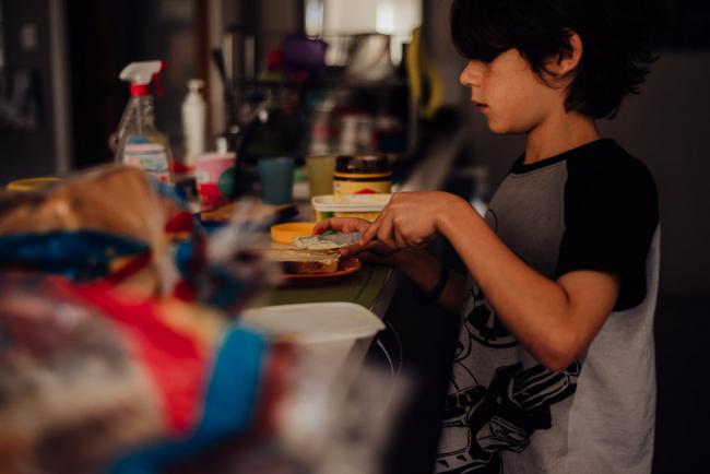 Boy making toast by family photographer perth