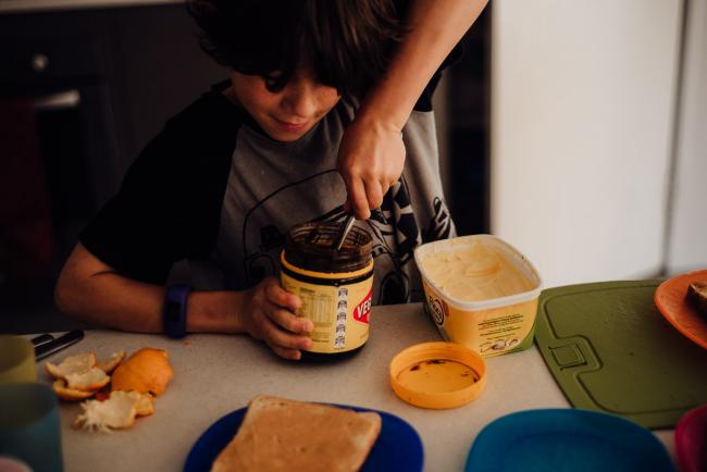 Boy reaching into vegemite by family photographer perth