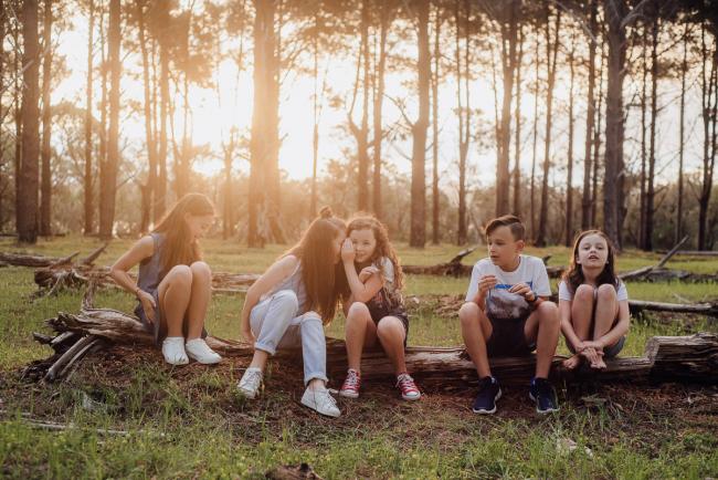 20181005-DSC_1244 Cousins sitting on a log playing chinese whispers during Perth family photography session at The Pines Wanneroo