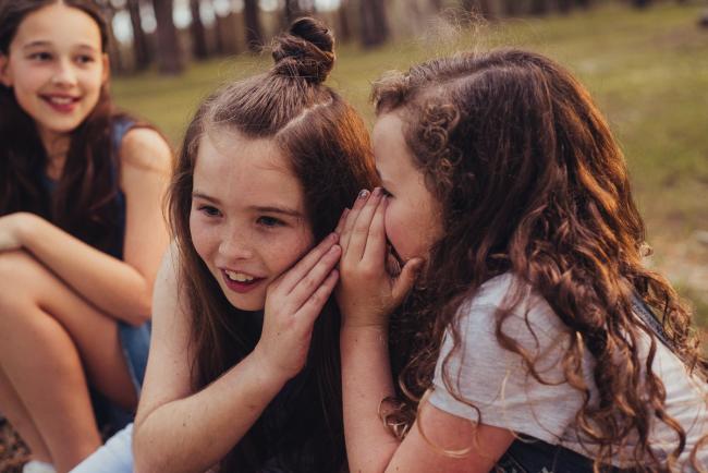 20181005-DSC_1291 Girl whispering into her sisters ear during Perth family photography session at The Pines Wanneroo