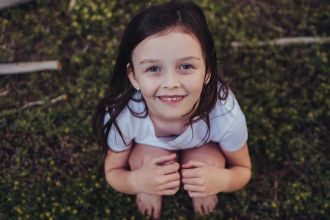 20181005-DSC_1383 Girl squatting and smiling at the camera during Perth family photography session at The Pines Wanneroo