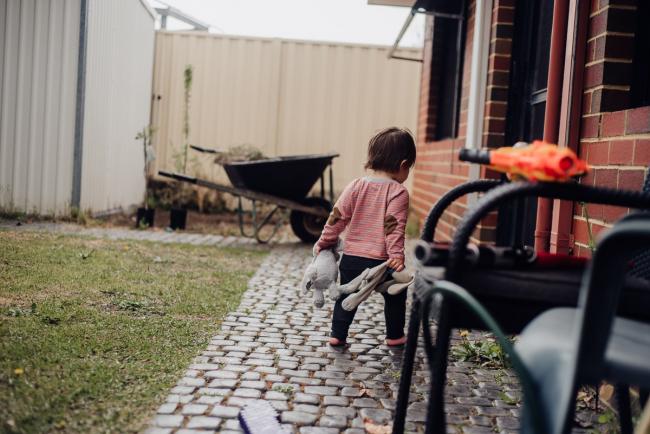 Little boy walking outside with his toy bunnies by family photographer perth