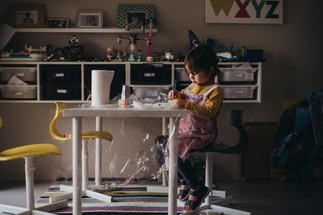 Little boy sitting painting in a craft room with family photographer Perth