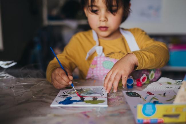 Little boy painting a canvas with family photographer Perth