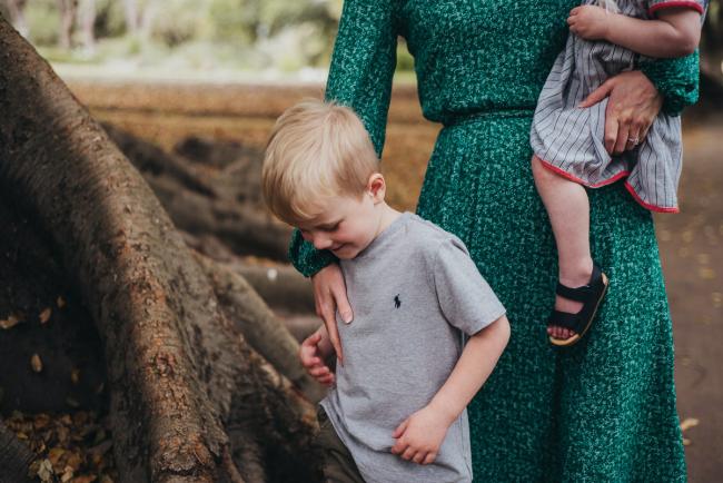 Mother with her arm protectively over her son during a family photography session at Hyde Park in Perth