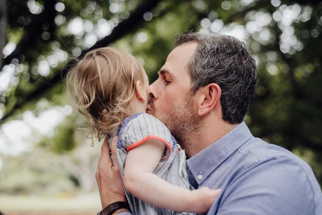 Dad kissing his daughter during a family photography session at Hyde Park in Perth