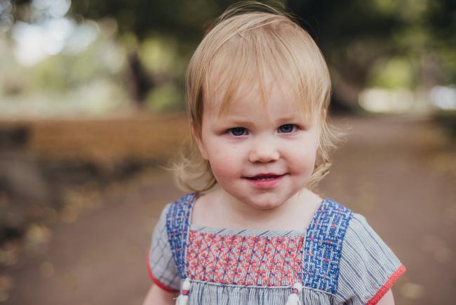 Little girl smiling during a family photography session at Hyde Park in Perth