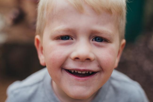 Close up of smiling boy during a family photography session at Hyde Park in Perth