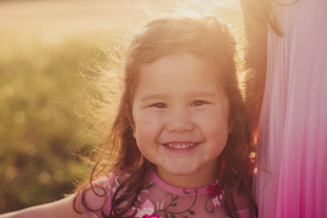 Little girl smiling during a golden hour family photography session at Perry's Paddock in Perth
