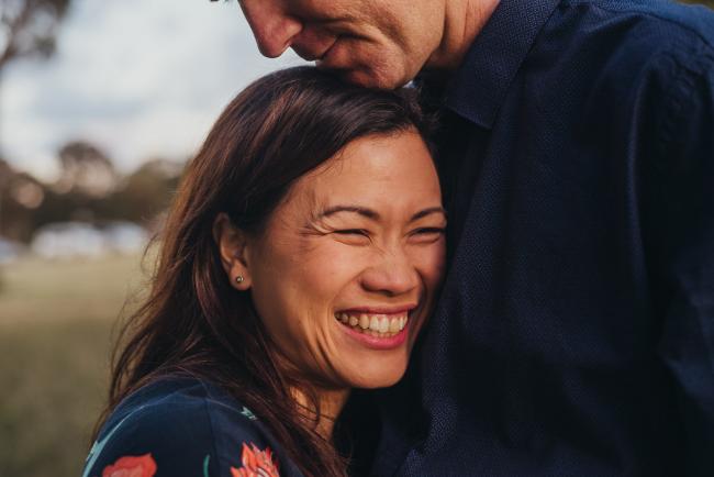Woman cuddled into her husband's chest during a golden hour family photography session at Perry's Paddock in Perth