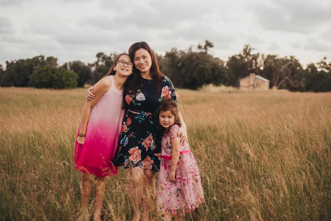 Mother and her two daughters during a golden hour family photography session at Perry's Paddock in Perth