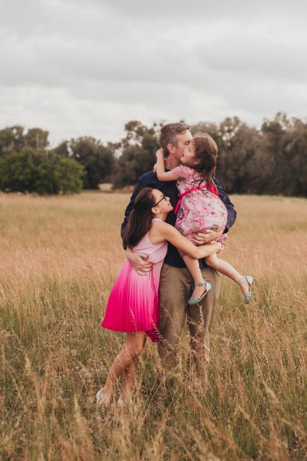 Father and his two daughters during a golden hour family photography session at Perry's Paddock in Perth