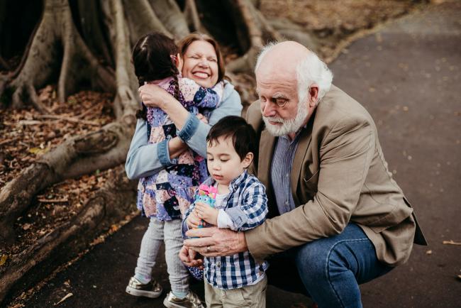 20180908-DSC_2181 Grandmother is hugged by granddaughter as grandfather plays with grandson and bubbles during extended family photography Perth session at Hyde Park