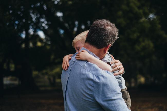 Father and son hugging in Hyde Park during a family photography session in Perth