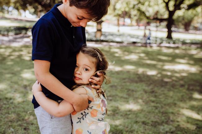 Big brother and little sister hugging during a mini session with Perth family photographer at Hyde Park