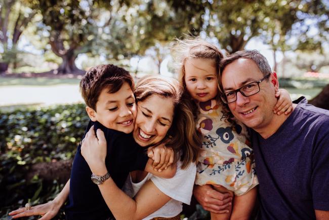 Family of four cuddling each other during a family photography session in Hyde Park, Perth