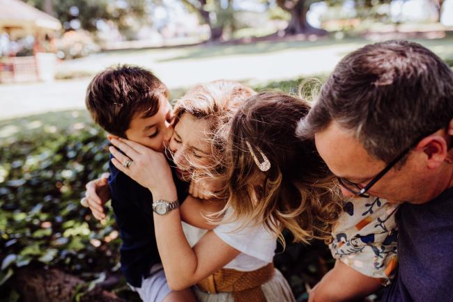 Family of 4 hugging and laughing during a mini session with Perth family photographer at Hyde Park