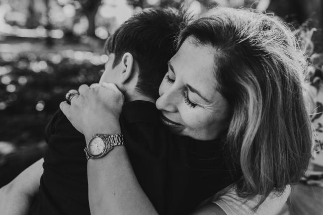 Black and white image of mother and son hugging during a mini session with Perth family photographer at Hyde Park