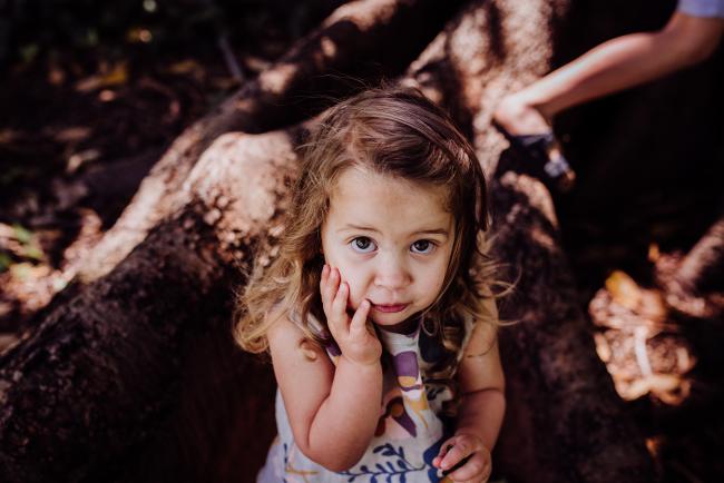 Little girl looking up during a mini session with Perth family photographer at Hyde Park