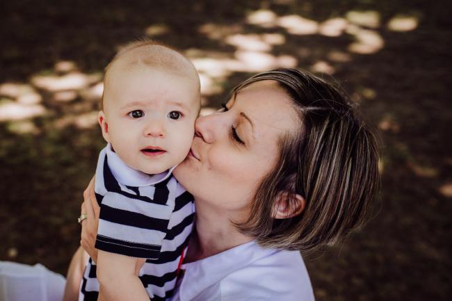 mother kissing her baby son during a mini session with Perth family photographer at Hyde Park