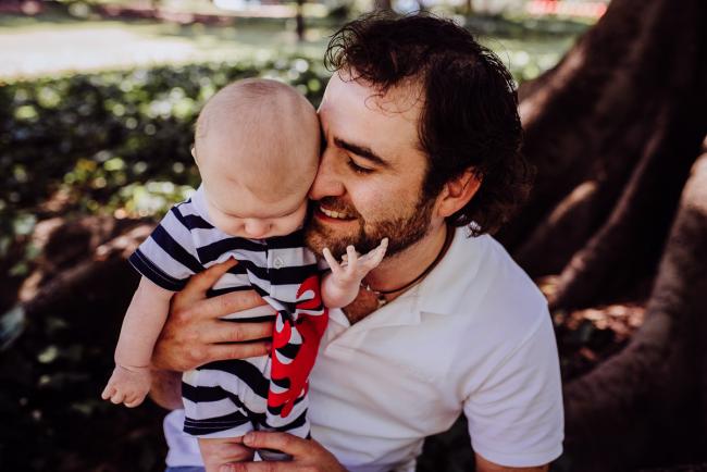 Father nuzzling into his baby son during a family photography session in Hyde Park, Perth