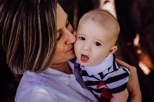 Mother kissing her baby son during a mini session with Perth family photographer at Hyde Park