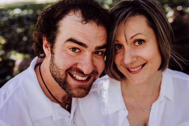 Couple smiling at the camera during a mini session with Perth family photographer at Hyde Park