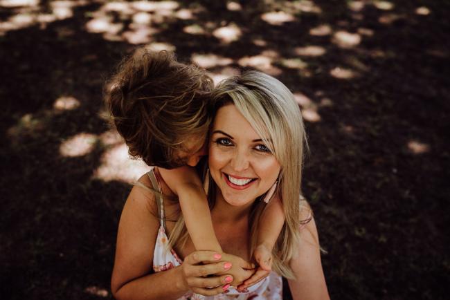 20181104-DSC_7006 Mother smiling with her son wrapping his arms around her neck during a mini session with Perth family photographer at Hyde Park