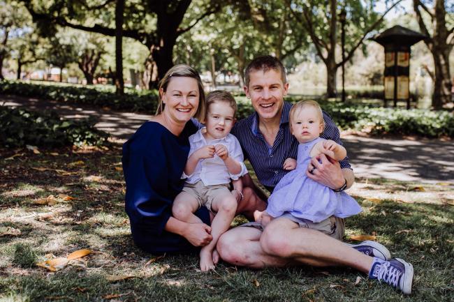 Family of 4 sitting on the grass during a mini session with Perth family photographer at Hyde Park