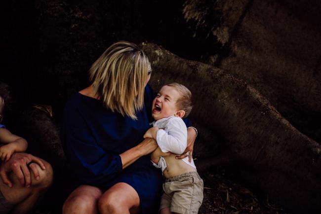 Little boy being tickled by his mum during a mini session with Perth family photographer at Hyde Park
