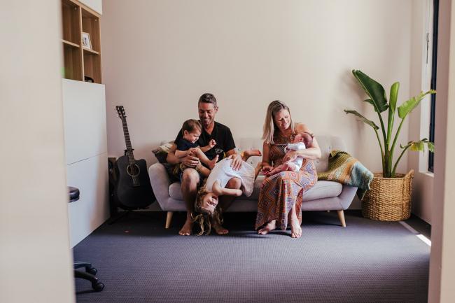 20181111-DSC_8078-2 Family of 5 on a couch with their new baby and the daughter hanging upside down in a lifestyle family photography session Perth