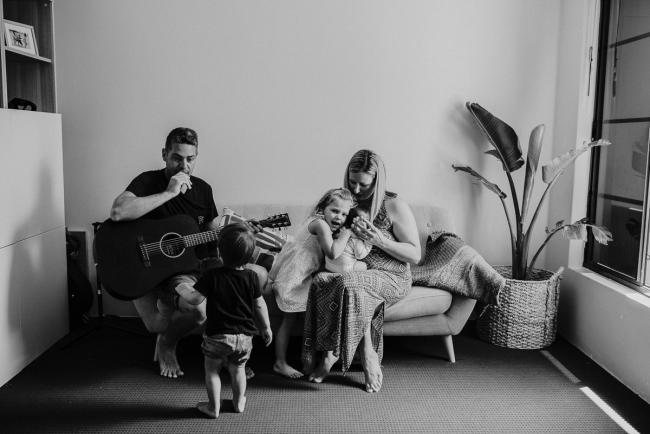 20181111-DSC_8090-1 black and white image of a family on the couch while dad plays guitar in a lifestyle family photography session Perth