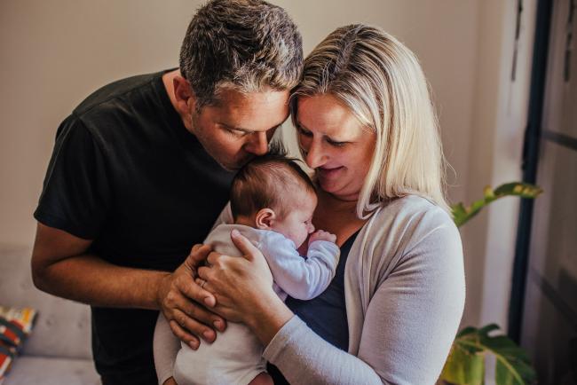 20181111-DSC_8301 mother and father kissing their new baby in a lifestyle family photography session Perth