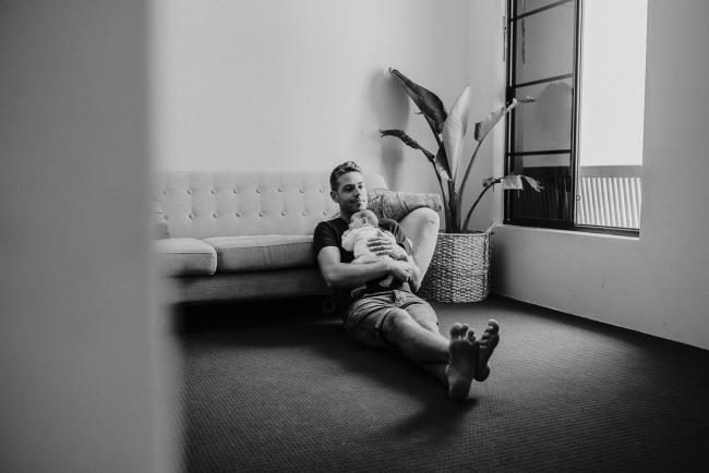 20181111-DSC_8519-2 black and white image of dad holding his new baby on the floor in a lifestyle family photography session Perth