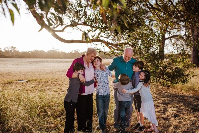 Grandaprents hugging their grandchildren during golden hour family photography session at Perry's Paddock Perth