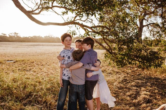 Cousins cuddling during golden hour family photography session at Perry's Paddock Perth