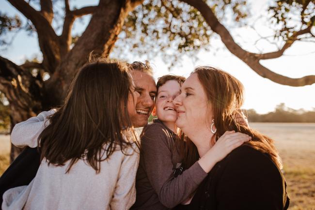 Family faces cuddling against each other during golden hour family photography session at Perry's Paddock Perth