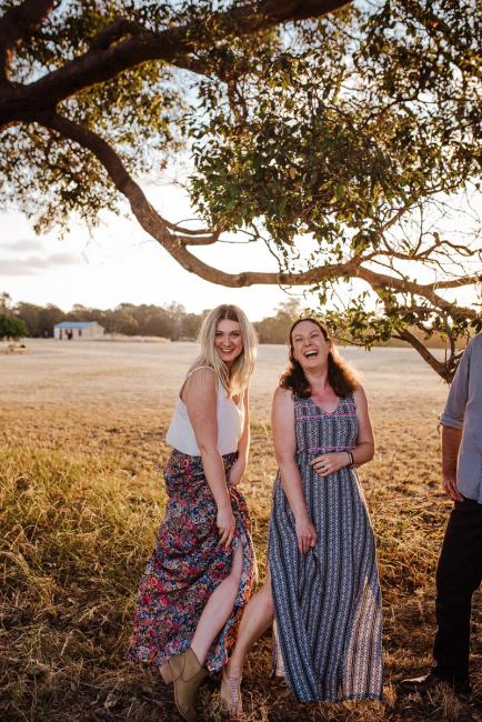 Two sisters showing off their legs during golden hour family photography session at Perry's Paddock Perth