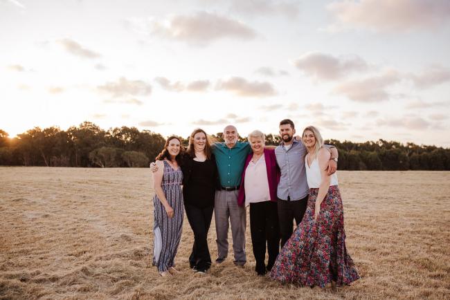 Family standing with their arms around each other during golden hour family photography session at Perry's Paddock Perth