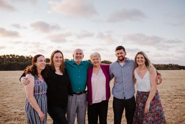 Family standing with their arms around each other during golden hour family photography session at Perry's Paddock Perth