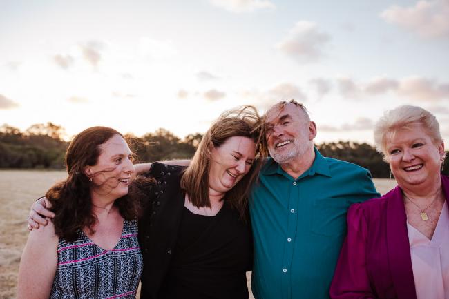 Grown daughter leaning against her father during golden hour family photography session at Perry's Paddock Perth