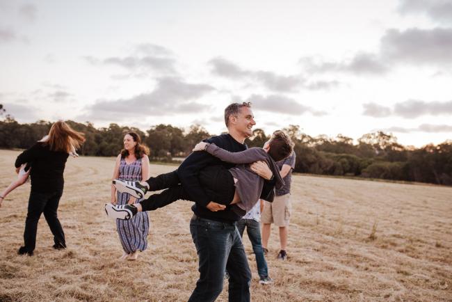 Family spinning together during golden hour family photography session at Perry's Paddock Perth
